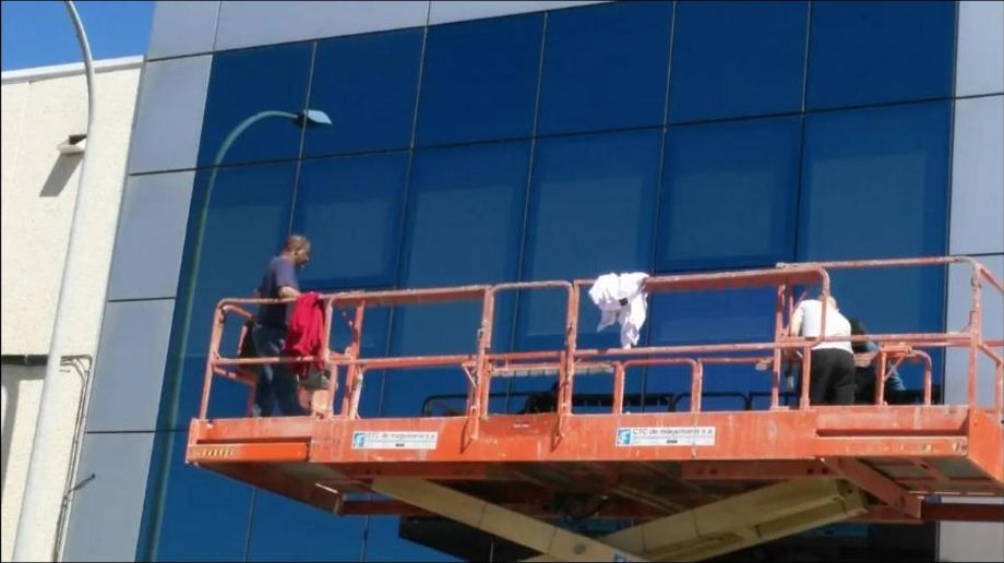 Operarios limpiando cristales desde plataforma