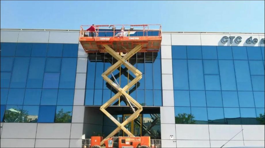 Limpieza de fachada acristalada con plataforma de tijera